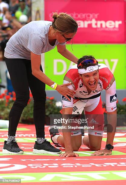 Jan Frodeno of Germany is greeted by his wife Emma Snowsill as he wins with a new world record time for long distance triathlon during the Challenge...