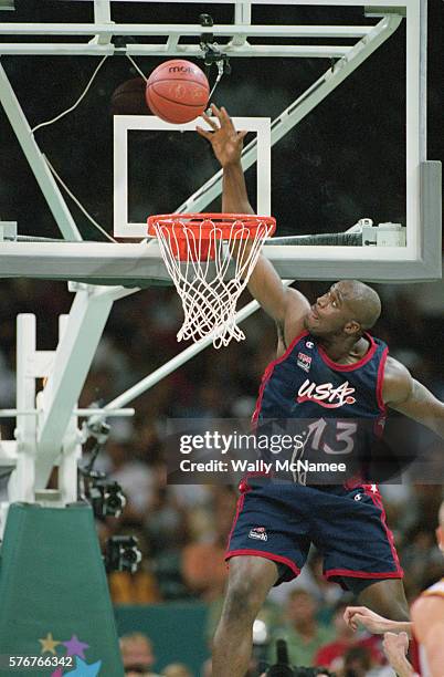 Shaquille O'Neal of the USA reaches high above the basket to slam the ball through the hoop in a basketball game against Lithuania at the 1996 Summer...