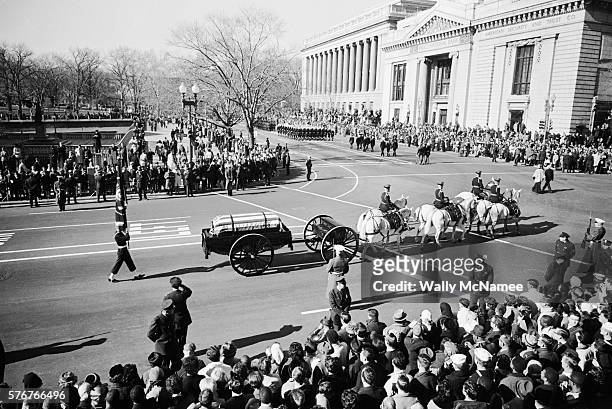 Horse-drawn caisson carrying the body of John Fitzgerald Kennedy passes mourners lining the streets of Washington, DC.