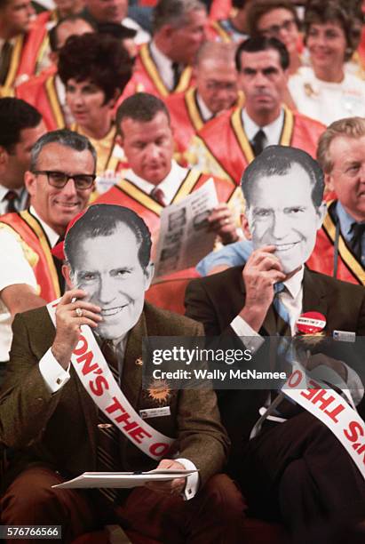 Delegates at the 1972 Republican National Convention hold Nixon masks up to their faces and wear "Nixon's the One" sashes in support of President...