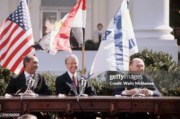 Egyptian president Anwar el-Sadat, US President Jimmy Carter, and Israeli Prime Minister Menachem Begin sit together in the sunshine outside the...