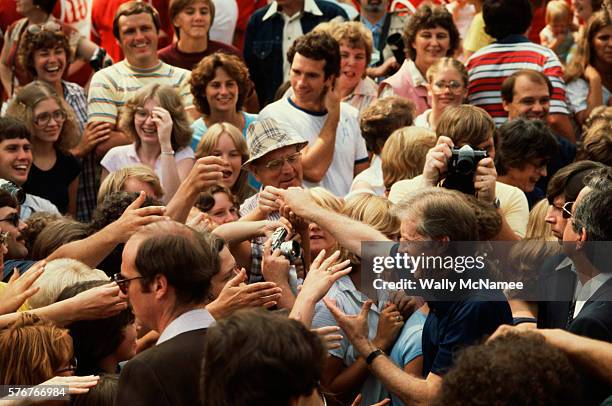 President Jimmy Carter shakes hands with a throng of Wisconsinites during a summer vacation touring the Mississippi River on the Delta Queen...