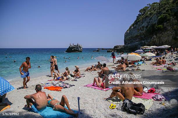 People enjoy the blue waters and the sandy beach at Milopotamos beach on July 10, 2016 in Pelion,Greece. On the Aegean side of East Pelion is the...