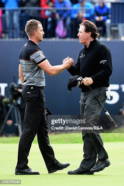 Henrik Stenson of Sweden is congratulated by Phil Mickelson of the United States on the 18th green during the final round on day four of the 145th...