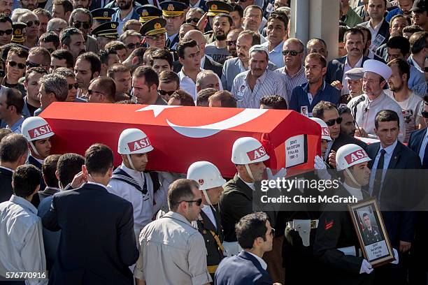People watch on as the body of a victim killed in Friday's failed coup attempt is carried past during a funeral service held at Kocatepe Mosque on...
