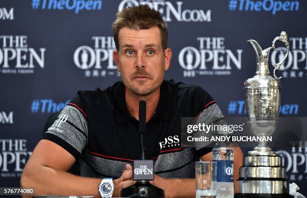 Sweden's Henrik Stenson answers questions from members of the media as he sits with the Claret Jug, the trophy for the Champion golfer of the year at...