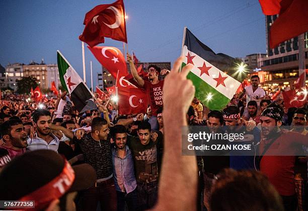 Demonstrators wave the flag of the Syrian opposition and Turkish flags at Taksim square in Istanbul on July 17, 2016 during a demonstration in...