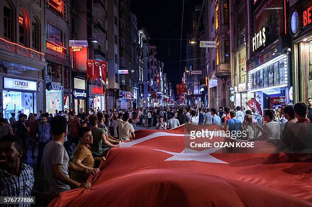 Pro-Erdogan supporters hold a Turkish flag as they gather at Taksim square in Istanbul to support the government on July 17 during a demonstration in...