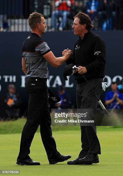 Henrik Stenson of Sweden celebrates victory on the 18th green with Phil Mickelson of the United States after the final round on day four of the 145th...