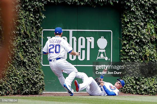 Albert Almora Jr. #5 of the Chicago Cubs tosses the ball to Matt Szczur after making a catch and colliding with the wall against the Texas Rangers...