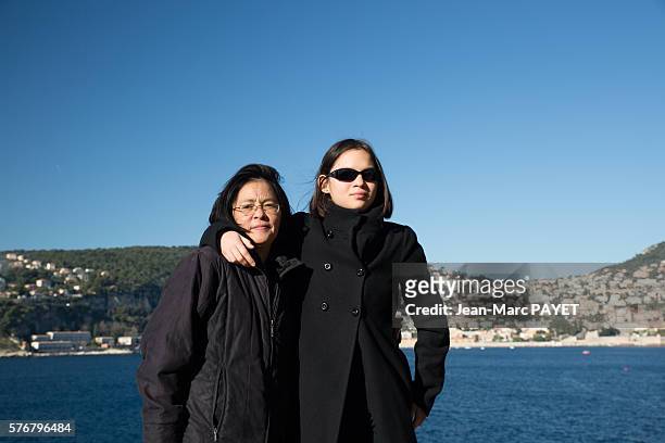 asian mother and her daughter in front of the sea - jean marc payet stock-fotos und bilder