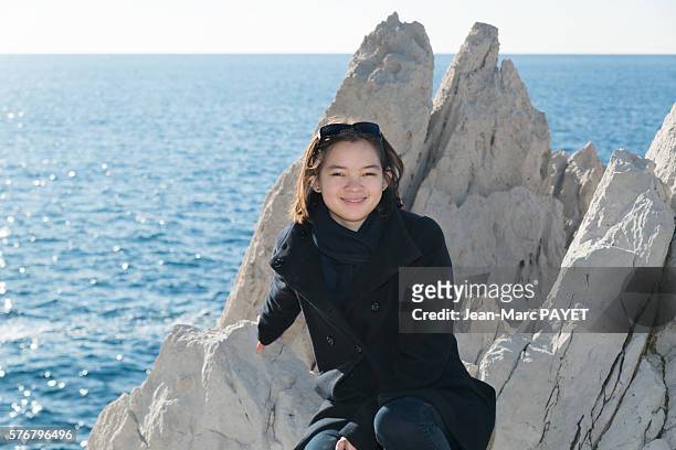 asian girl on the rocks - jean marc payet stock-fotos und bilder