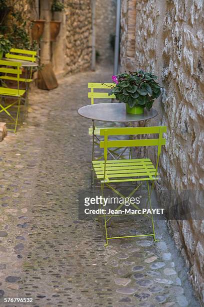 chairs and tables on a typical village's street - jean marc payet stock-fotos und bilder