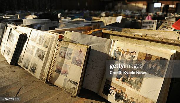 Japan - Items including family photo albums retrieved from debris after the March 11 quake and tsunami are lined up in a gymnasium in Natori, Miyagi...
