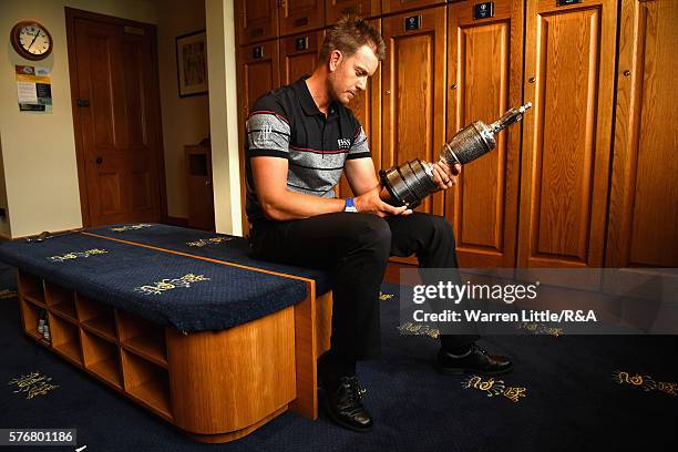 Henrik Stenson of Sweden looks at the Claret Jug in the Champions Locker Room following his victory during the final round on day four of the 145th...