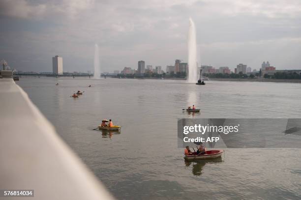 Photo taken on July 17, 2016 shows a general view of rowing boats on the Taedong river before the Pyongyang skyline.