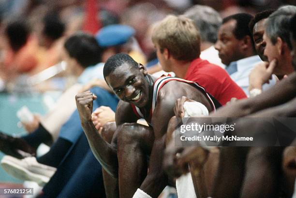 Basketball player Michael Jordan clenches his fist while sitting on the bench during a game at the 1984 Olympics in Los Angeles.