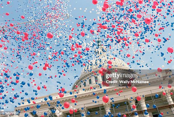 red, white, and blue balloons over the u.s. capitol building - us politics - fotografias e filmes do acervo