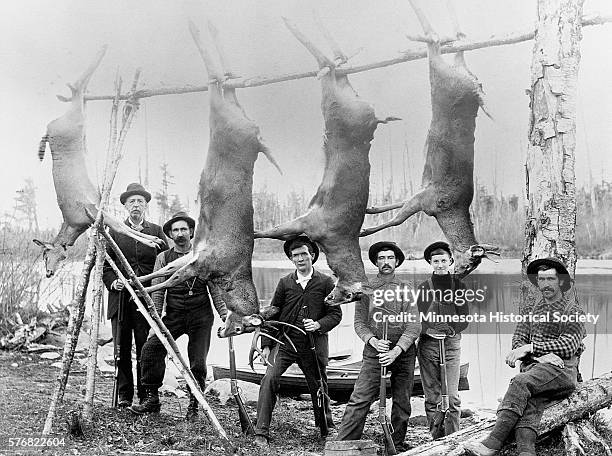 Hunters Standing with Hanging Deer