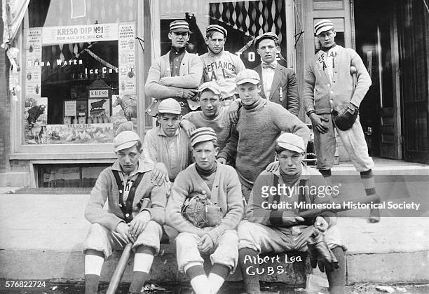 The Albert Lea Cubs minor league baseball team poses for a portrait on a sidewalk in the town.