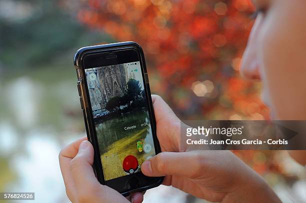In this photo illustration a young woman plays Pokemon GO in front of Sagrada Familia, on July 15, 2016 in Barcelona, Spain.