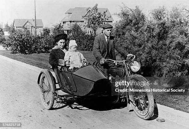 Moody takes his wife and baby for a ride in the sidecar of his motorcycle.