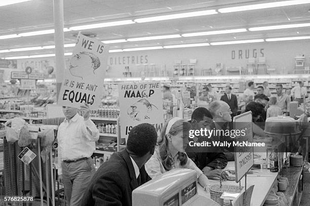 Demonstrators staging a sit-in at a drug store lunch counter in Arlington, VA, are picketed by American Nazi Party members. The sit-in people were...