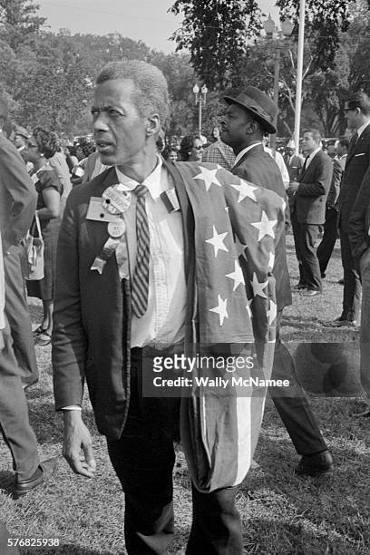 This March on Washington participant carries an American flag on his shoulder, Washington DC, August 28, 1963.