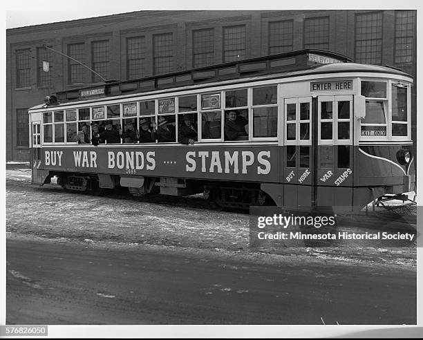 Advertisements urging riders to buy war bonds and stamps decorate the Selby-Lake streetcar in Minneapolis. Both were available from the streetcar...