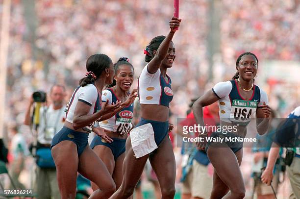 Gail Deves, Inger Miller, Chryste Gaines, and Gwen Torrece celebrate their gold medal performance in the 4x100m medley relay race at the Atlanta...