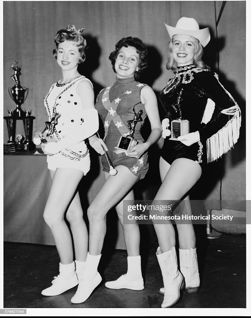 Women in Costumes Holding Trophies
