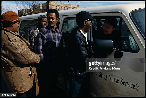 Homeless African Americans talk with a volunteer from the Love Gospel Assembly along the street. The Love Gospel Assembly serves five-star meals to...