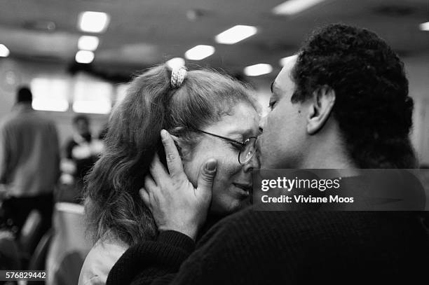 Woman prisoner gets a kiss from a family member at a Christmas party in prison on Rikers Island. | Location: Rikers Island, New York, USA.