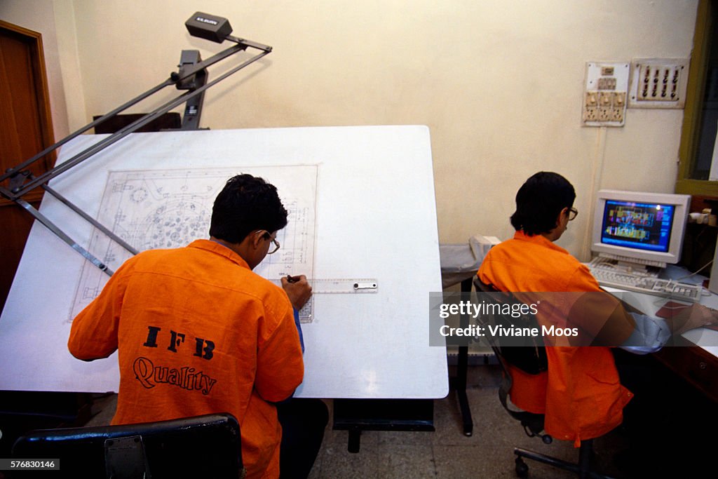 Engineers Working at Computer and Drafting Table