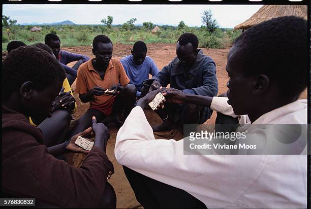 Refugees play a game of dominoes in Atepe, Sudan. Civil war and widespread famine have ravaged Sudan for decades, resulting in more than 2 million...