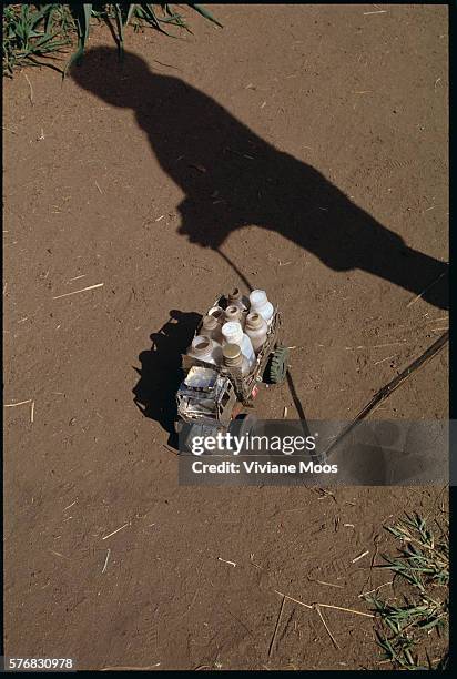 Child in the refugee camp of Aswa, Sudan, casts his shadow near a toy truck that is filled with make-believe food supplies. Civil war and widespread...