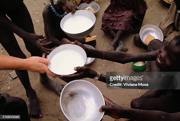 An young boy receives a bowl of milk at a feeding center in Kongor, Sudan. Civil war and widespread famine have ravaged Sudan for decades, resulting...