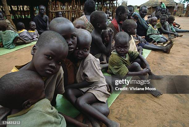 Refugee children await a meal at the feeding center in Ame, Sudan. Civil war and widespread famine have ravaged Sudan for decades, resulting in more...