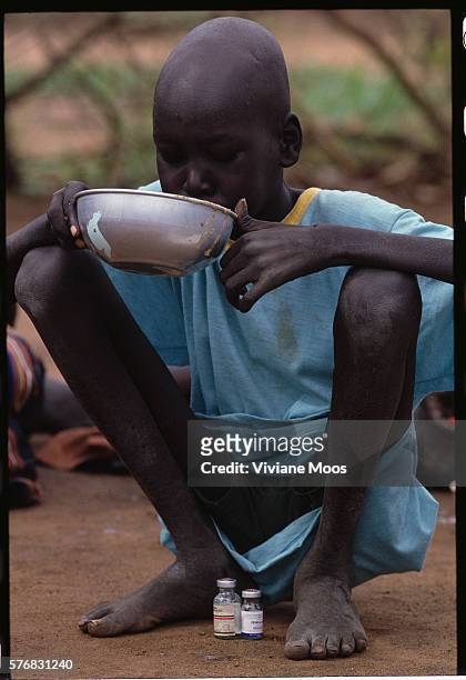 Refugee child eats food at a feeding center in Ame, Sudan. Civil war and widespread famine have ravaged Sudan for decades, resulting in more than 2...