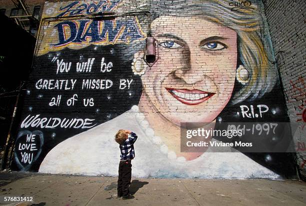 Boy gazes up at a mural of Princess Diana which is on a brick wall along Houston Street in Manhattan's East Village.