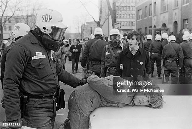 Officers from the Washington, DC, Metropolitan Police Civil Disturbance Unit wearing helmets and gas masks arrest anti-war demonstrators near the...