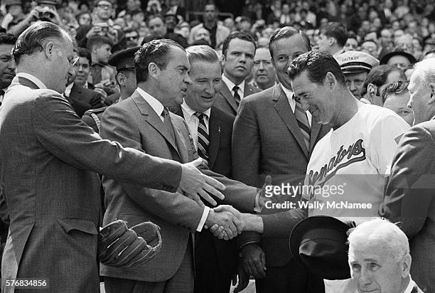 Baseball Commissioner Bowie Kuhn holds out his hand as President Richard Nixon shakes hands with Ted Williams. Former Senators pitcher Sid Hudson...
