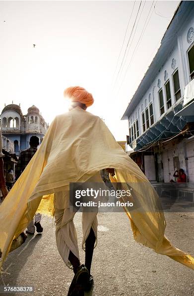 Indian Man Robe An unrecognizable Indian man wearing flowing robes and an orange ...
