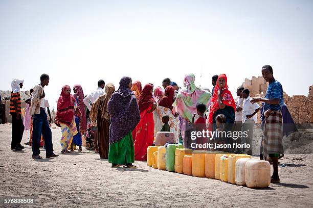 Goup of Somalis with plastic water containers wait at a distribution point operated by Puntland Maritime Police Force . The Puntland Maritime Police...