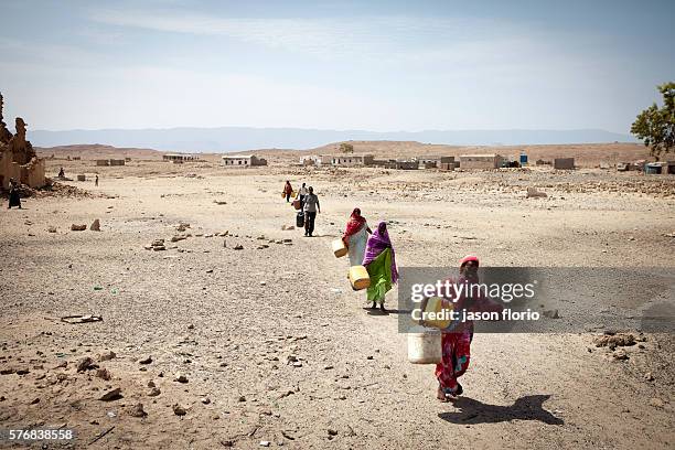 Somalis carrying water containers to a distribution point operated by Puntland Maritime Police Force . The Puntland Maritime Police Force is a...
