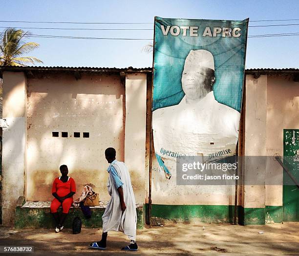 Billboard of Gambia's President Yayah Jammeh in a Gambian village. The letters on the billboard have been torn, ironically to no longer read as...