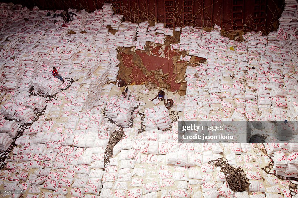 At the Port of Cotonou,Benin. men unload rice sacks from the hold of ...