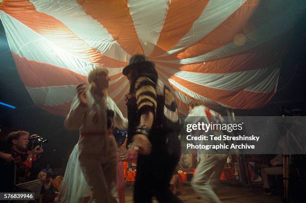 Doris Delay, wearing a white jumpsuit, dances with a member of the Hell's Angels at the Acid Test Graduation. During this celebration, which was...