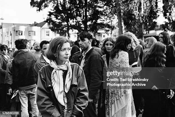 Writer Joan Didion walks among hippies during a gathering in Golden Gate Park, San Francisco.