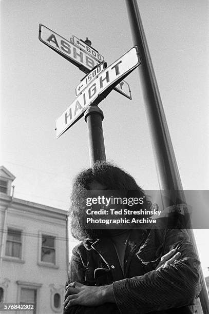 Jerry Garcia of the Greatful Dead stands under the street signs on the corner of Ashbury and Haight streets in San Francisco. | Location: corner of...